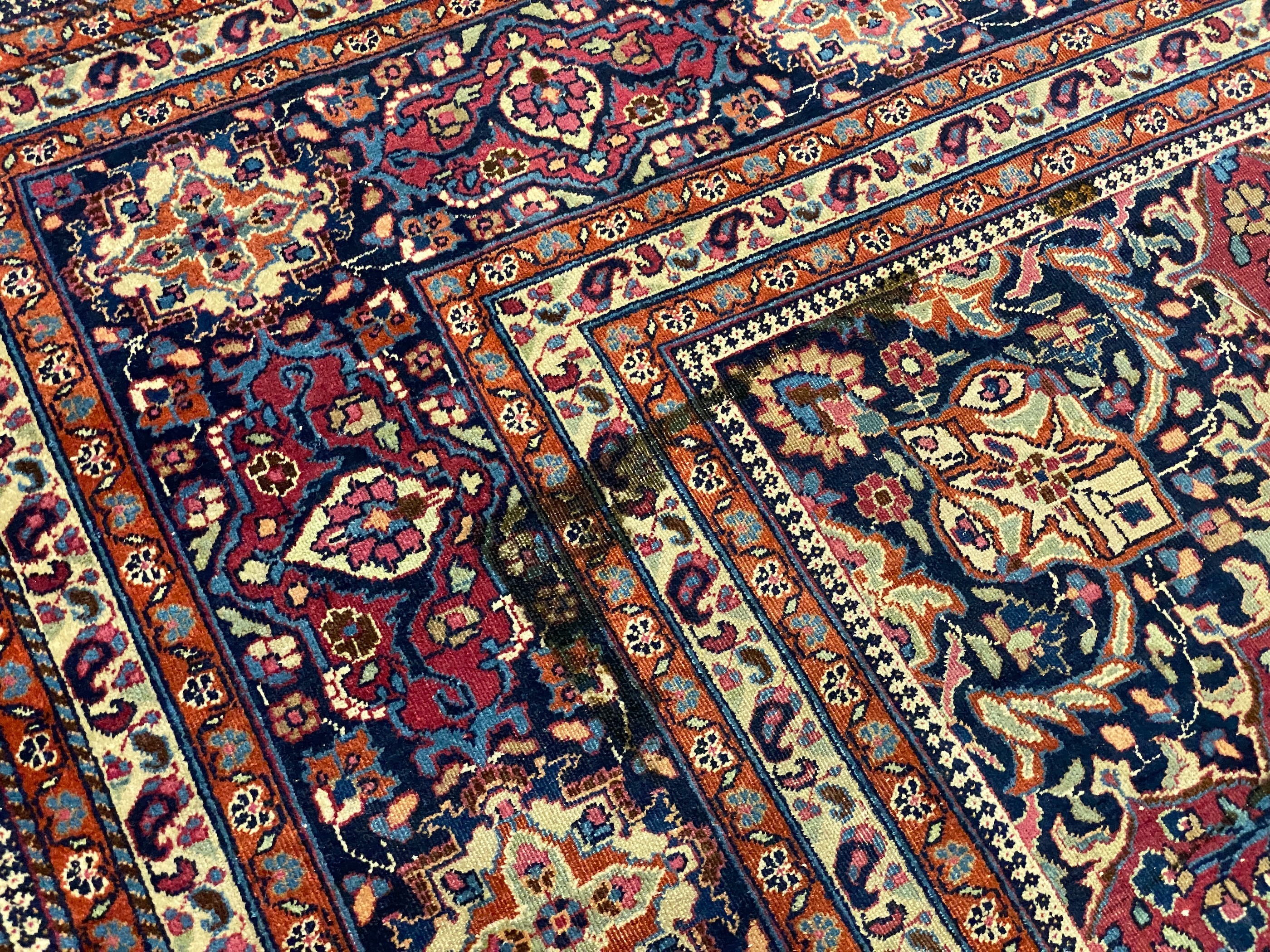An early 20th century Heriz burgundy ground carpet, 412 x 305cm